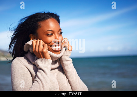 Ritratto di giovane donna holding rollneck su un maglione a Beach, Malibu, California, Stati Uniti d'America Foto Stock