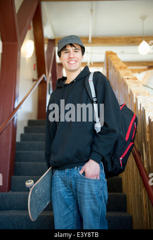 Studente su scala con lo skateboard Foto Stock