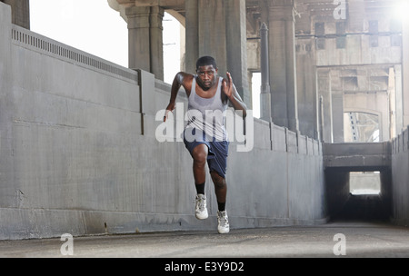 Giovane uomo velocità oltre il ponte della città Foto Stock