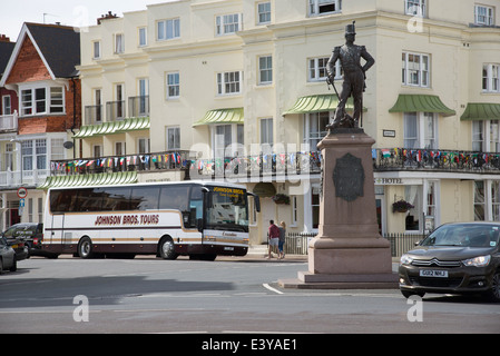 Inglese resorts Holiday autobus fuori dall'hotel e il Royal Sussex Regimental statua 1920 su Marine Parade, Eastbourne East Sussex Foto Stock