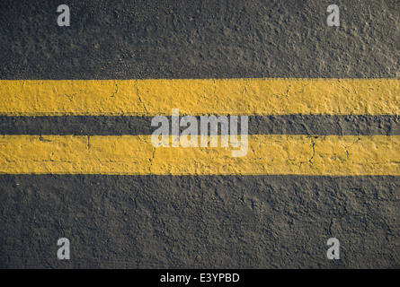 Doppio giallo divisore di linee su asfalto Foto Stock