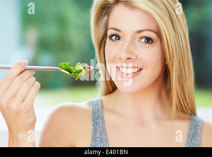 Bella ragazza mangiare insalata sana Foto Stock