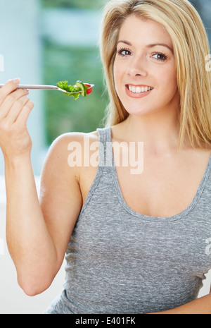 Bella ragazza mangiare insalata sana Foto Stock