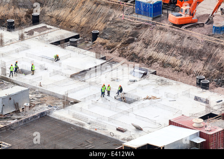 Sito in costruzione con lavoratori che fanno foundation Foto Stock