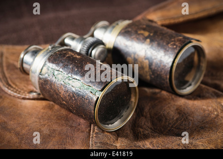 Chiusura del vecchio binocolo giacente sul cappuccio in pelle. Foto Stock