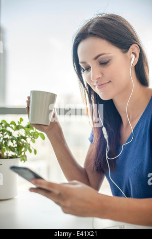 Giovane donna ascoltare musica sullo smartphone Foto Stock
