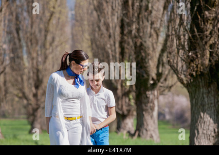 Ragazzo di dodici anni e matura madre passeggiare e chat Foto Stock