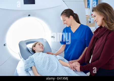 Radiologo e madre rassicurante ragazza di andare in CT scanner Foto Stock