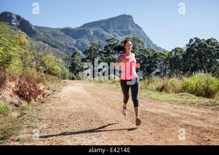 Giovane donna jogging in foresta Foto Stock