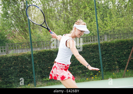 Donna matura giocando a tennis Foto Stock