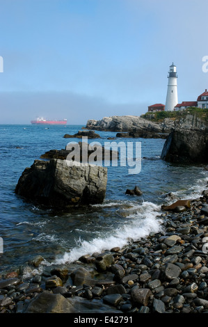 Portland Guide faro rosso nave cisterna lungo la costa rocciosa attraverso la nebbia al di fuori del porto di Portland sul Casco Bay nel Maine. Foto Stock