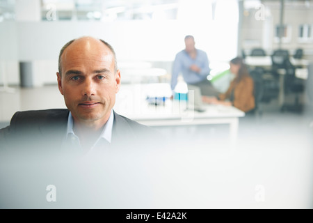 Uomo che guarda in telecamera, matura in background Foto Stock