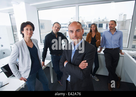 Gli imprenditori in posa per il ritratto di gruppo in ufficio Foto Stock