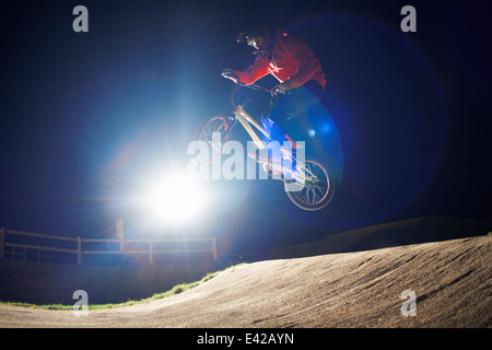 BMX-ciclista salta la sua bici di notte Foto Stock