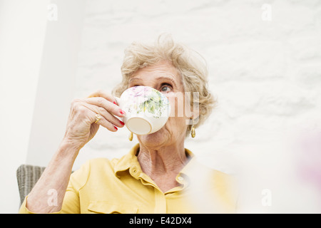 Senior donna bere il tè Foto Stock