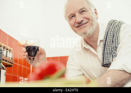 Senior uomo con vino rosso, ritratto Foto Stock