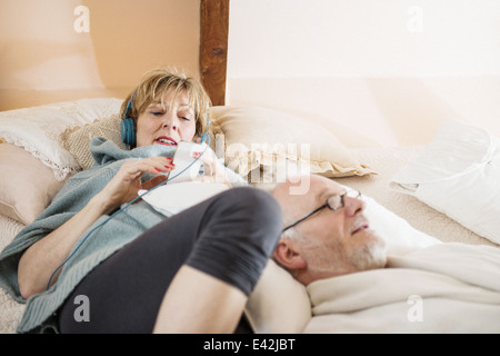 Giovane giacente sul letto rilassante Foto Stock