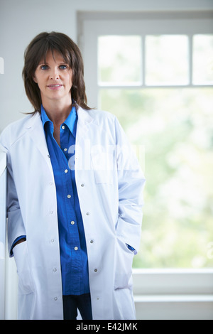 Medico con le mani nelle tasche del camice Foto Stock
