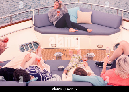 Gruppo di amici adulti gustando un drink rilassante a bordo di yacht Foto Stock