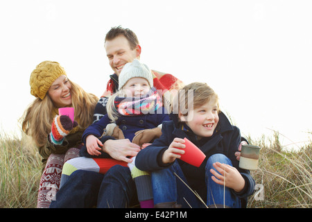 Sorridente metà adulto giovane con due bambini a costa Foto Stock
