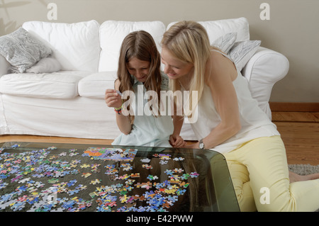 Madre aiutare mia figlia fare puzzle Foto Stock