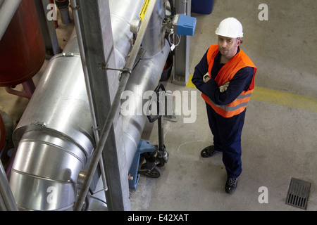 Angolo alto ritratto maschile di tecnico nella stazione di alimentazione Foto Stock