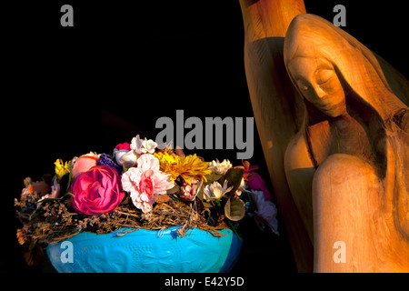 Madonna in legno scultura con fiori in vaso blu Foto Stock