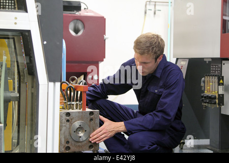 Ingegnere maschio mantenendo la macchina di produzione in fabbrica Foto Stock