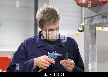 Ingegnere maschio rendendo la riparazione delle attrezzature in fabbrica Foto Stock