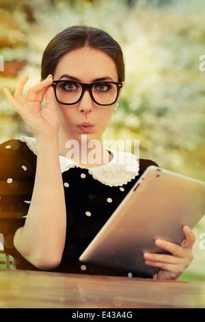 Sorpreso giovane donna con gli occhiali e tablet Foto Stock