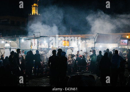La folla si riuniranno presso chioschi in piazza Jemaa El-Fná Fnaa (Piazza Grande) di notte a Marrakech, Marocco Foto Stock