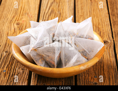 A forma di piramide a jasmine bustine di tè in ciotola di legno Foto Stock