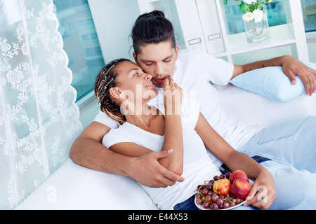 Immagine della ragazza di mettere un'uva nel suo fidanzato bocca Foto Stock