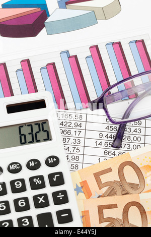 Una calcolatrice e varie statistiche per il calcolo del bilancio, entrate e profitti. Foto Stock