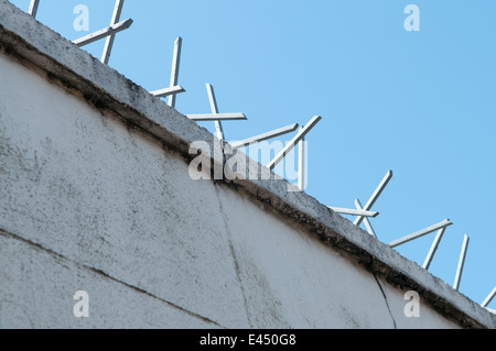 Punte di sicurezza sulla parte superiore di una parete. Foto Stock