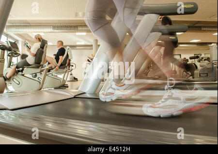 Atleta femminile esercitando su un tapis roulant in una palestra, Oberhausen, Nord Reno-Westfalia, Germania Foto Stock