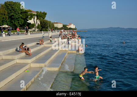 Visitatori crogiolarsi al sole del pomeriggio presso l'organo di mare dall'architetto Nikola Bašić, Zara, Dalmazia, Croazia Foto Stock