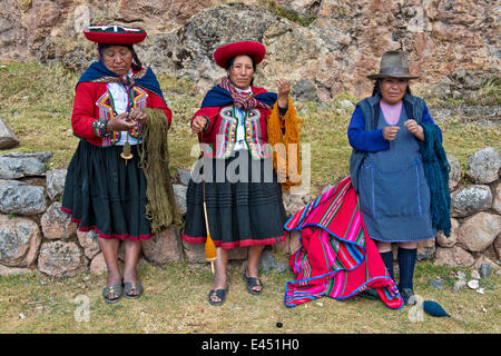 Tre donne anziane indossare cappelli, gli Indiani Quechua in abito tradizionale la filatura della lana di legno di mandrini, Cinchero Foto Stock