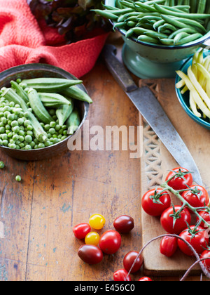 Ancora la vita di verdure fresche con pomodori a grappolo, piselli e okra Foto Stock