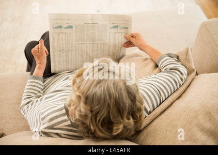 Senior donna leggendo il giornale Foto Stock