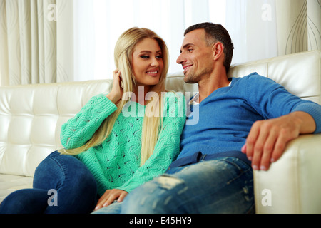 Felice coppia giovane su un divano a casa Foto Stock