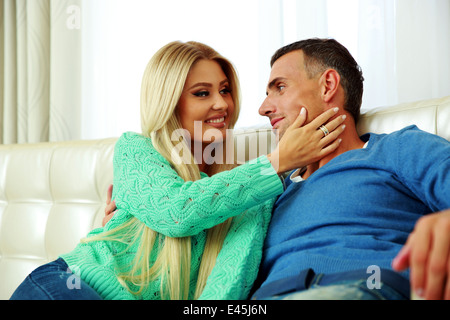 Felice coppia giovane su un divano a casa Foto Stock