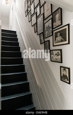 Cornice foto in bianco e nero sulla parete lungo la scala Foto Stock