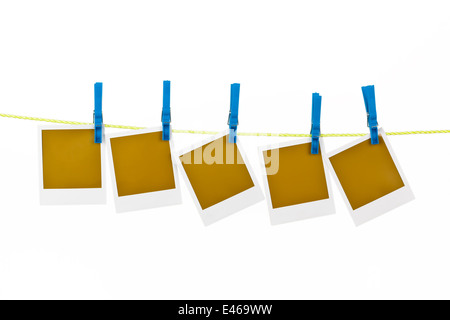 Varie fotografie appese su uno stendibiancheria e sono fissati con clothespins Foto Stock