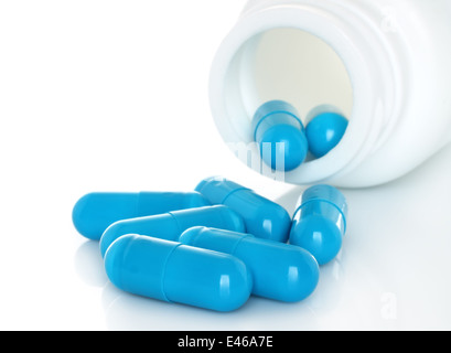 Pills versare dal flacone bianco su sfondo bianco Foto Stock