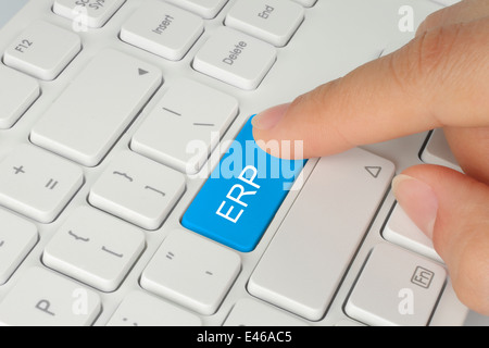 Mano che spinge il blu ERP (enterprise resource planning) sul pulsante bianco sullo sfondo della tastiera Foto Stock