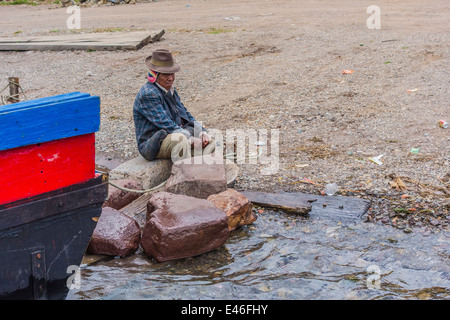 Un uomo e il fiume traghetti attraverso lo stretto di Tiquina, Bolivia prendere automobili, camion, autobus e moto attraverso il fiume. Foto Stock