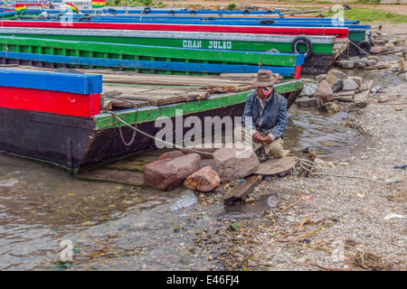 Un uomo e il fiume traghetti attraverso lo stretto di Tiquina, Bolivia prendere automobili, camion, autobus e moto attraverso il fiume. Foto Stock