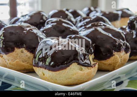 In casa eclairs sono coperti con uno strato di glassa al cioccolato Foto Stock