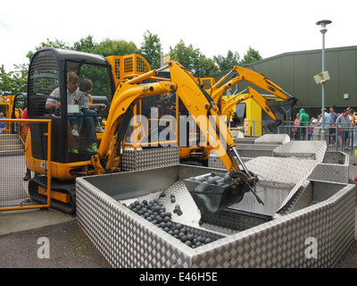 Un padre e un bambino sulla JCB Digger sfida attrazione a Legoland Windsor. Foto Stock